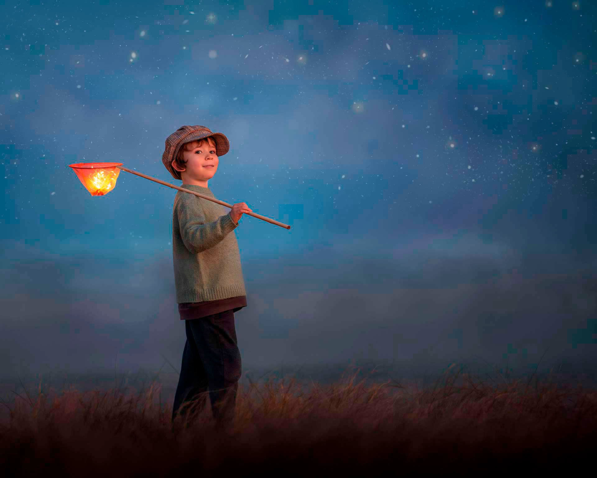 Niño con sombrero y linterna en una escena mágica de noche, fotografía infantil estilo fine art realizada por Caro Roig en Uruguay