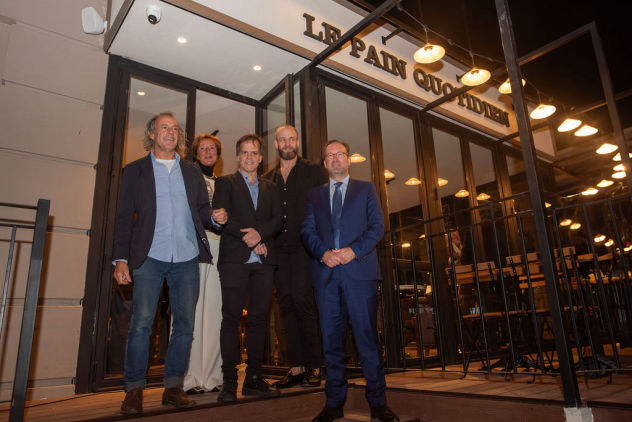 Directivos posando en la entrada de Le Pain Quotidien durante un evento empresarial nocturno – cobertura fotográfica por Caro Roig.