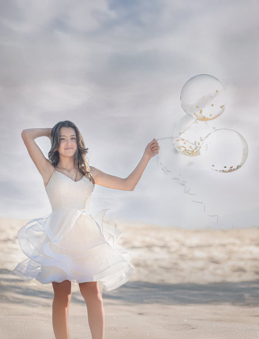 Fotografía de 15 años en exteriores en la playa de Ciudad de la Costa. Sesión luminosa y natural con vestido blanco y globos.