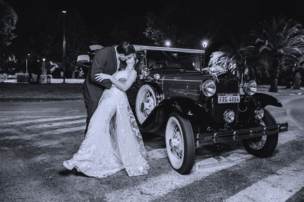 fotografia exteriores novios beso con cachilo de fondo ciudad de la costa uruguay